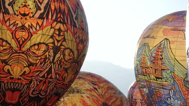 Colorful hot air balloons flying over the scenic mountain landscape of Wonosobo, Central Java, Indonesia, during a festive outdoor event