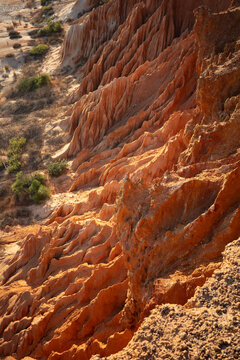 Red rock formations near a dry area, showing unique shapes and patterns in the landscape