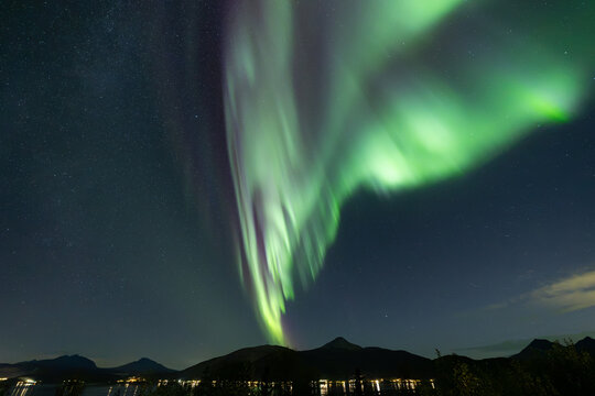 A beautiful shot of bright green aurora northern lights over mountains in Norway