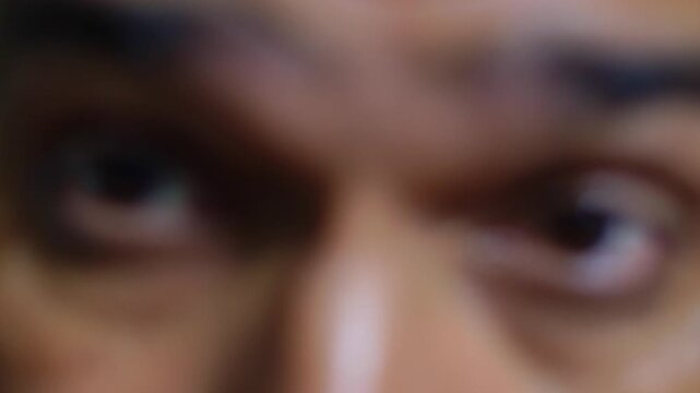 Blurry close up of a person's eyes with an intense, threatening, and angry stare looking directly into the camera
