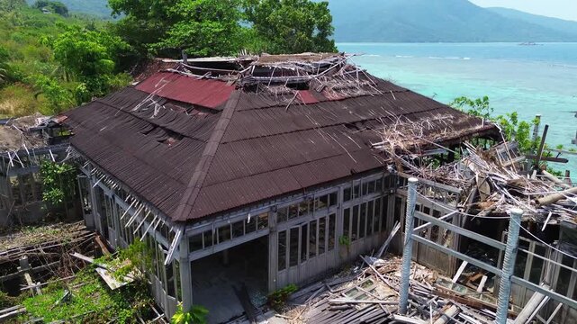 Rising Drone shot of Abandoned Wooden Resort Building Revealing Tropical Beach