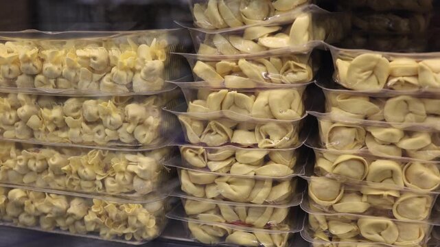 Fresh tortellini and stuffed pasta packed in clear containers displayed for sale showing Italian food variety convenient meal preparation grocery retail a food selection