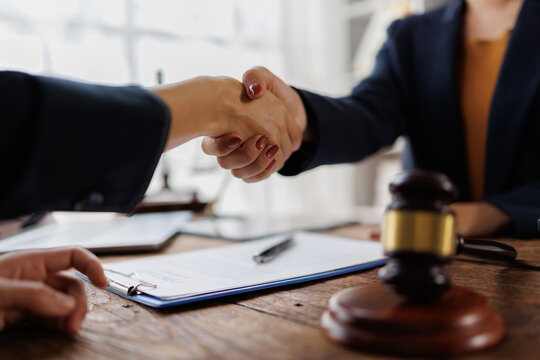 Legal professional client handshake on desk, reaching agreement, concluding consultation, discussing contract terms, justice and law partnership, counsel support