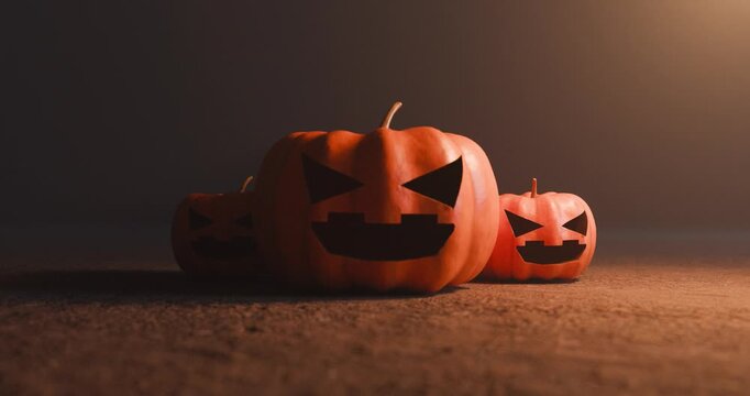 Three carved halloween jack o lanterns on ground with side pumpkin suddenly turning to face camera
