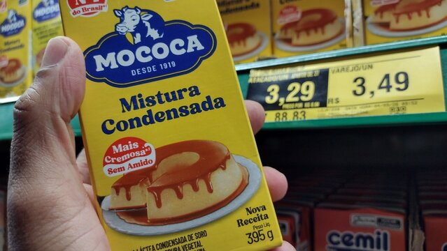 ITABIRA, BRAZIL - SEPT 19, 2026: Hand holding Mococa condensed mixture next to a R$ 3.49 price tag in a supermarket, illustrating cheaper dairy substitutes amid rising food commodity production costs.
