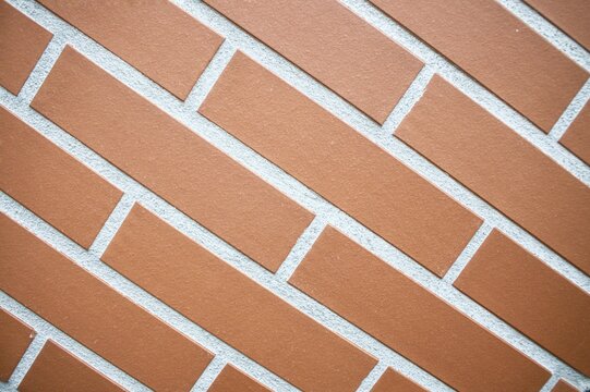 Modern brown brick tile pattern texture background on exterior wall surface