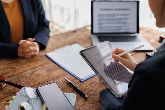Legal consultant and client reviewing and digitally signing a contract on a tablet during a business meeting, illustrating modern paperless legal processes and efficient e signature workflow