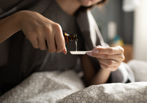Crop woman pouring syrup in spoon