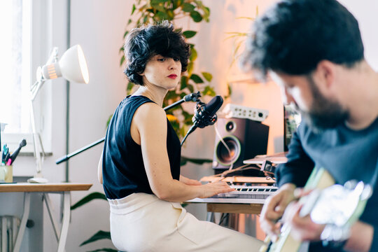Couple collaborating making music in home recording studio