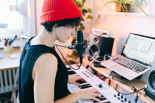 Musician creating music in home studio recording new song