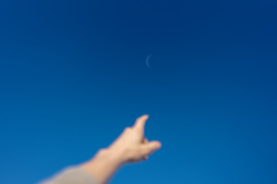 Hand Pointing at Crescent Moon