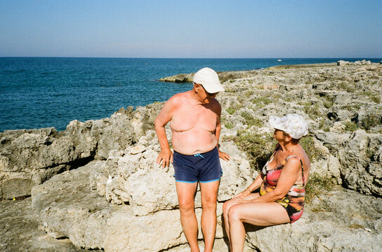 Senior Couple resting on rocky coast  by the Sea