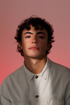 Young Man Poses With Expression Against Pink Background