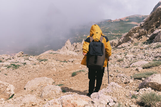 Hiking through rocky terrain with a backpack on a cloudy day