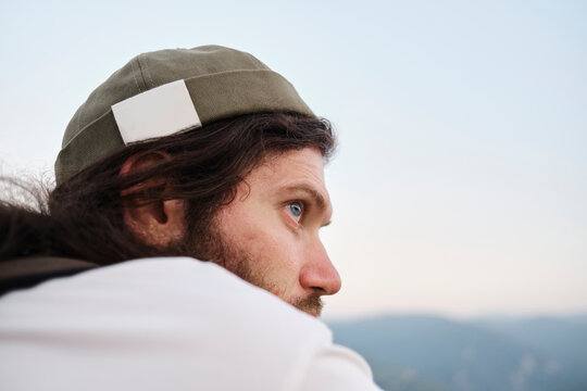 Man sitting outdoors looking at the horizon in the mountains