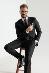 Confident man sitting on wooden stool posing © Viorel Sima