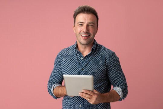 Cheerful man holding digital tablet