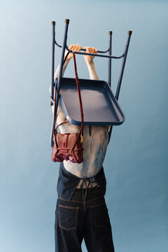 Surreal Fashion Portrait With Chair And Handbag
