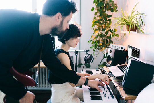 Couple collaborating on music production in home studio