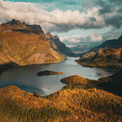 Vertical aerial view of a majestic fjord surrounded by golden autumn mountains in Norway with copy space in sky © Quality by Simon