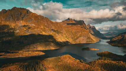 Vertical aerial view of a majestic fjord surrounded by golden autumn mountains in Norway with copy space in sky © Quality by Simon