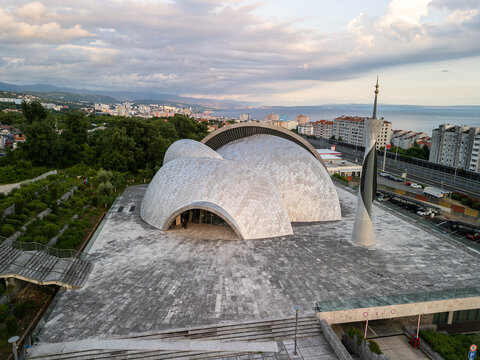 Rijeka, Croatia - 05 18 2025: Angled drone photo from down showing the Islamic Center of Rijeka (Islamski centar u Rijeci) with stairs in front and left, highway with cars and high buildings 