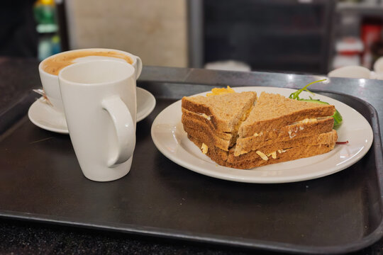 Cheese sandwich on wholemeal bread with flat white coffee on caf