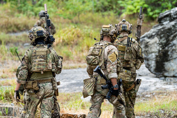 Fototapeta premium Soldiers training in a wooded area during a military exercise focused on teamwork and tactics