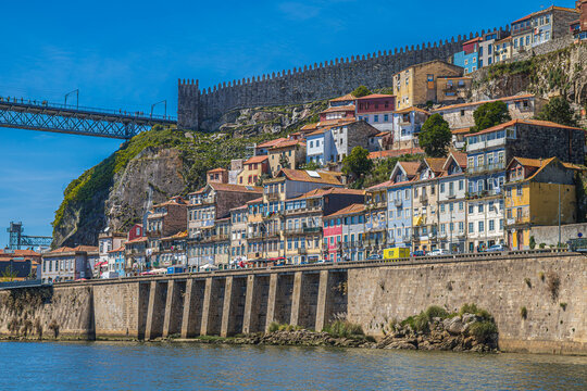 Porto, Portugal &ndash; April 11, 2024: The historic Ribeira district, featuring traditional colorful houses along the banks of the Douro River and the famous medieval walls (Muralha Fernandina).