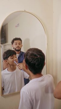 Father teaching son proper dental hygiene