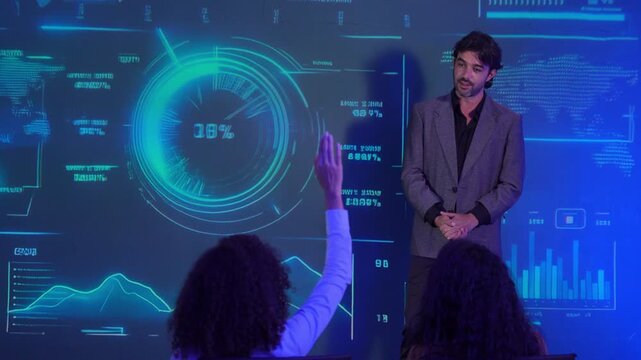 Business professional presents to an audience in front of a futuristic digital interface displaying charts, graphs, and data analytics. business strategy, technology, leadership, data visualization.