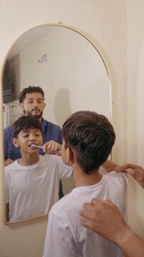 Father teaching son dental hygiene routine