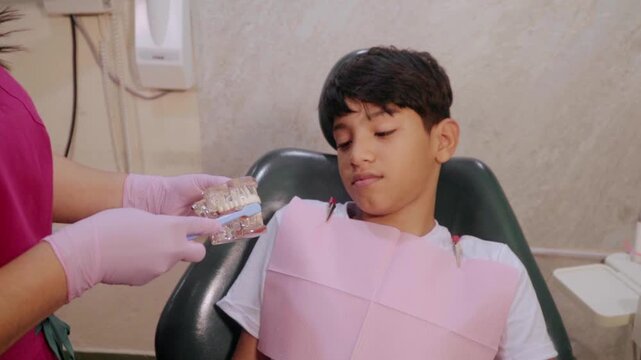 Dentist teaching young boy brushing technique