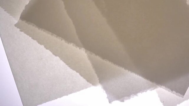 Overlapping translucent paper sheets slide gently through soft light in a minimal tactile seamless background.