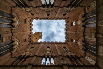 Obraz premium A lookup at the atrium of Palazzo Pubblico (town hall) palace in Siena historic center, Tuscany, Italy