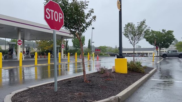 Gas station parking lot with stop sign on rainy overcast day