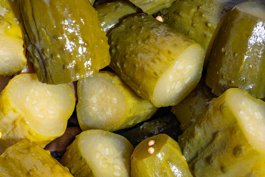 Glossy sliced pickled cucumbers with seeds showing interior texture
