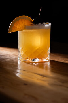 Beautiful Whiskey sour served on the rocks garnished with an orange slice and a dark cherry