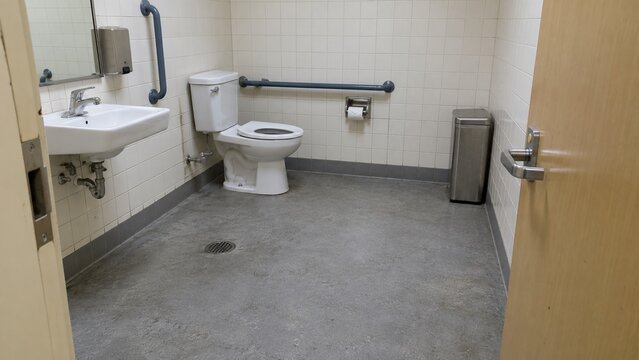 Accessible public restroom with grab rails and wide turning area