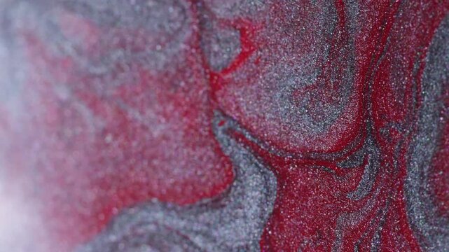 Paint spatter. Spill texture. Defocused red silver colorful blend particles acrylic liquid floating on abstract creative background.