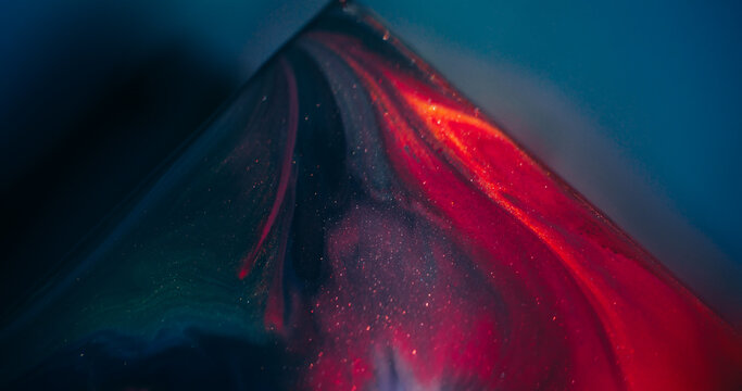 Color paint. Acrylic triangle. Defocused purple blue orange mix glitter texture flow on abstract art sparkling light background.