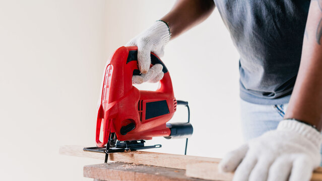 Person using red jigsaw tool