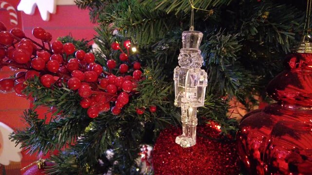 Glass nutcracker ornament hanging on christmas tree
