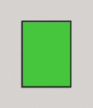 Blank green rectangular frame with decorative black border on a textured grey background
