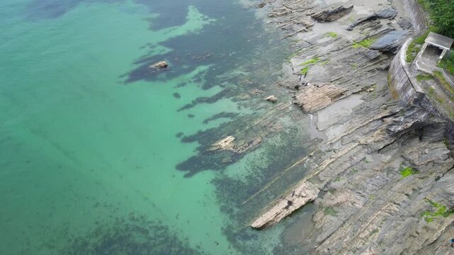 High Angle Footage of Beach and Ocean at Looe Town of England During Hot Sunny Day. Looe is a coastal town and civil parish in southeast Cornwall, England, United Kingdom.