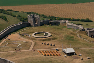 spis castle aerial view stone walls tower courtyard cannons wooden benches farmland slovakia medieval fortress ruins historic landmark concept of travel, history, tourism © Lana Pietukhova
