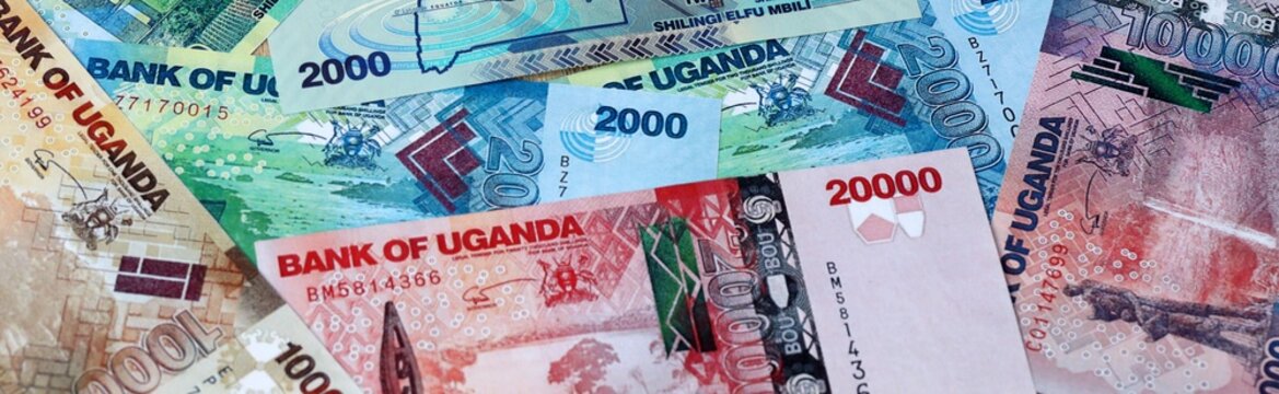 Ugandan shilling money bills in pile on table. Uganda UGX currency cash close up