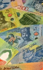 Brunei Darussalam dollar money bills in pile on table. Brunei BND currency cash close up © Viktor