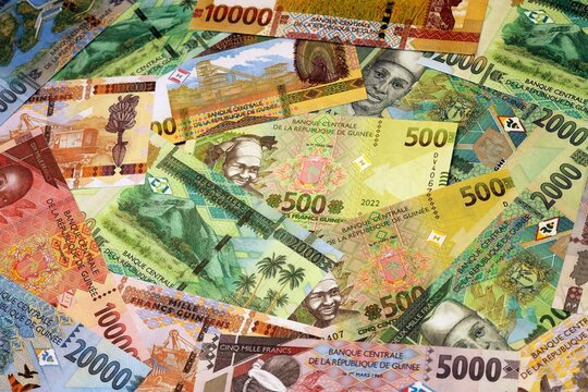 Guinean franc money bills in pile on table. Guinea GNF currency cash close up
