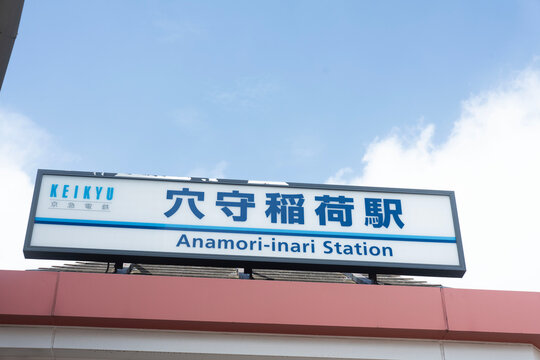青空に映える京急線の駅名看板が印象的な「穴守稲荷駅」のクリーンな外観スナップ